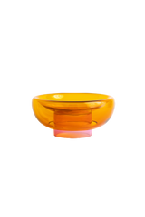 semi-transparent orange cylinder glass base holding a semi-transparent deep yellow moon shape glass forming a bowl on a white background