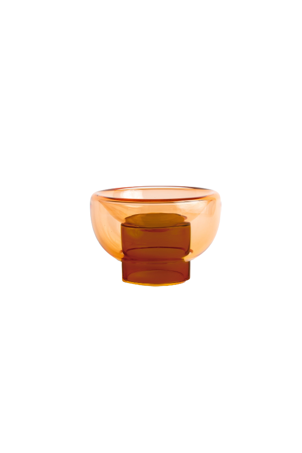 semi-transparent brown cylinder glass base holding a semi-transparent orange moon shape glass forming a bowl on a white background