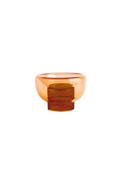 semi-transparent brown cylinder glass base holding a semi-transparent orange moon shape glass forming a bowl on a white background