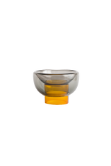 semi-transparent yellow cylinder glass base holding a semi-transparent grey moon shape glass forming a bowl on a white background