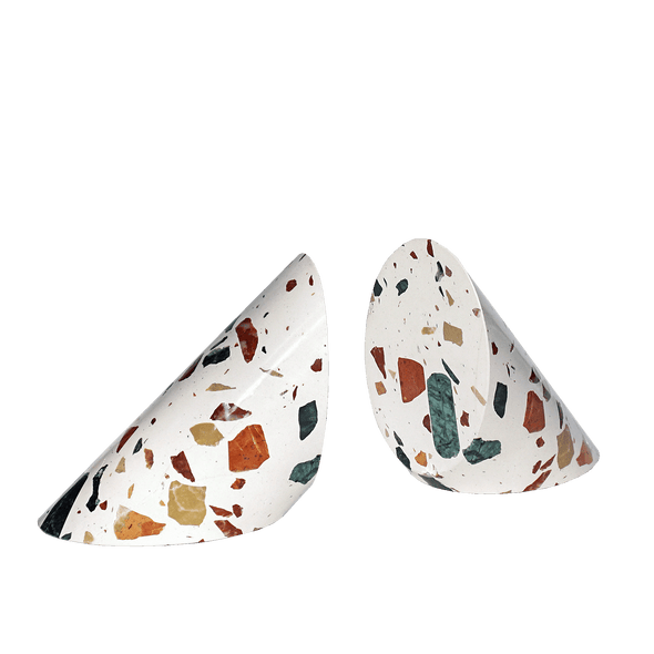set of two cylinder of terrazzo cut in a triangle shape containing natural earthy colors chips of stone on white background